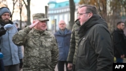 জার্মান প্রতিরক্ষামন্ত্রী বরিস পিস্টোরিয়াস, ডানে এবং কর্নেল হেনাদি কোভালেঙ্কোকে কিয়েভের মাইদান স্কোয়ারে "মাইদান হিরোস" স্মৃতিসৌধে ফুল দিতে দেখা যায়। (২১ নভেম্বর, ২০২৩)