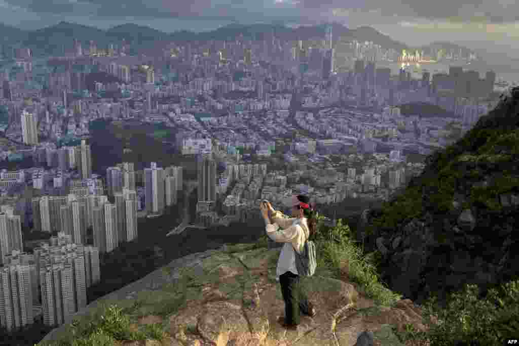 A hiker in Hong Kong takes a picture of the city from a walking trail.