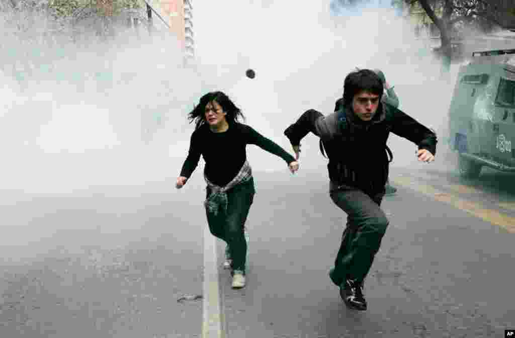 September 8: Students run from tear gas released by riot policemen during a rally at Santiago city as they are protesting the public state education system. REUTERS/Victor Ruiz Caballero