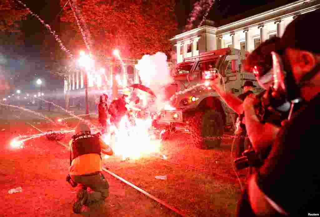 Flares go off in front of a Kenosha Country Sheriff vehicle as demonstrators take part in a protest following the police shooting of Jacob Blake, a Black man, in Kenosha, Wisconsin, Aug. 25, 2020. 