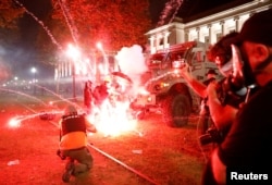 Flares go off in front of a Kenosha Country Sheriff vehicle as demonstrators take part in a protest following the police shooting of Jacob Blake, a Black man, in Kenosha, Wisconsin, Aug. 25, 2020.