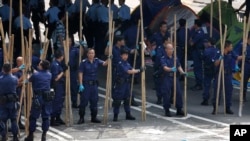 Police officers remove the bamboo barriers that protesters set up in Central district in Hong Kong, Oct. 14, 2014.