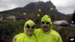 People dressed in alien costumes pose for a photo in front of Pic de Bugarach mountain at a small party in the town of Bugarach, France, Dec. 21, 2012.