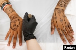Henna is applied to the hands and arms of a customer at the Le'Jemalik Salon and Boutique ahead of the Eid al-Fitr Islamic holiday in Brooklyn, New York, June 21, 2017.