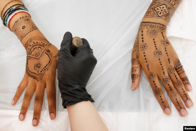Henna is applied to the hands and arms of a customer at the Le'Jemalik Salon and Boutique ahead of the Eid al-Fitr Islamic holiday in Brooklyn, New York, June 21, 2017.