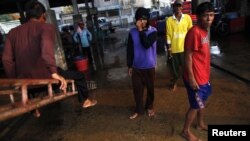 Migrant workers from Burma get off a fishing boat at a seafood market in the town of Mahachai, near Bangkok, Thailand, March 2010. 