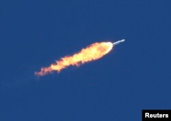 A SpaceX Falcon Heavy rocket trails flames after lifting off from historic launch pad 39-A at the Kennedy Space Center in Cape Canaveral, Feb. 6, 2018.