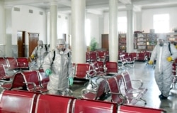 This undated picture released from North Korea's official Korean Central News Agency (KCNA) on Feb. 15, 2020, shows people in protective suits spraying disinfectant at an undisclosed location in North Korea amid concerns about the coronavirus.