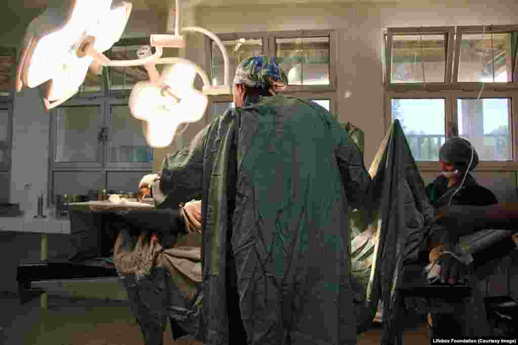 Nurse anaesthetist stands in front of patient, open on the table.