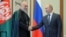 Russian President Vladimir Putin (R) and Afghan President Hamid Karzai shake hands during a meeting in Beijing, China, June 7, 2012. 