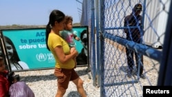 Una madre con su hijo entra al campo de refugiados de ACNUR en Maicao, Colombia, el 7 de mayo de 2019.