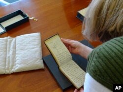 Jessica Gardner looks at the Tree of Life Sketch in one of naturalist Charles Darwin's notebook which have recently been returned after going missing. (Stuart Roberts/Cambridge University Library via AP)