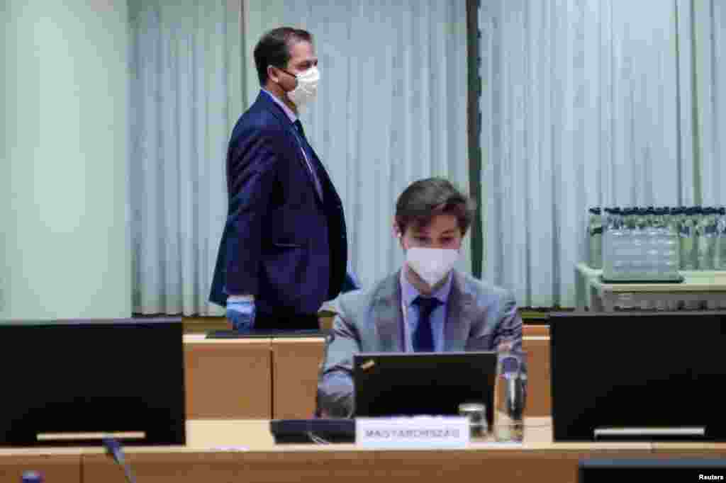 Un empleado del Consejo de la UE y un miembro de la representación húngara usan máscaras protectoras mientras asisten a una reunión del Comité de Representantes Permanentes de los Gobiernos de los Estados miembros ante la Unión Europea (COREPER) en el Consejo Europeo en Bruselas, Bélgica, el 8 de abril. 2020.&nbsp;