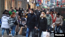 FILE: Christmas shoppers wear masks and fill Cologne's main shopping street Hohe Strasse (High Street) during the COVID-19 pandemic in Cologne, Germany, Dec. 12, 2020.