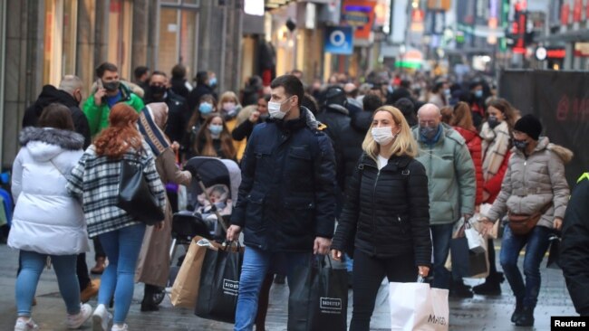 FILE: Christmas shoppers wear masks and fill Cologne's main shopping street Hohe Strasse (High Street) during the COVID-19 pandemic in Cologne, Germany, Dec. 12, 2020.