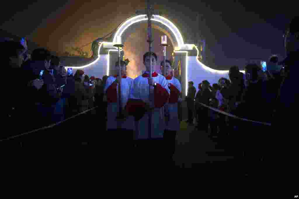 Cross-bearers walk through the church grounds during a Christmas Eve Mass at the Southern Cathedral, an officially-sanctioned Catholic church in Beijing, China.