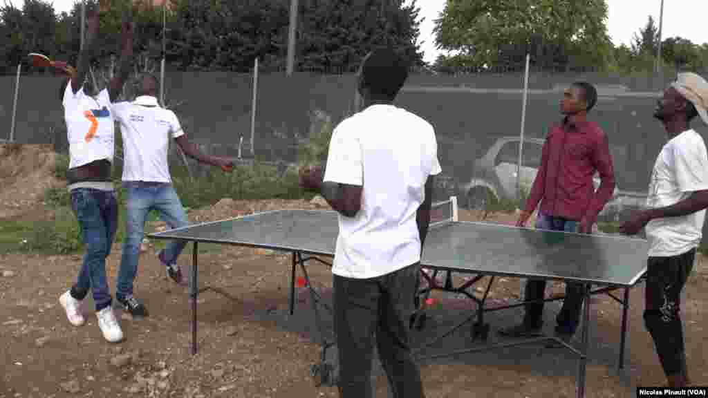 Des migrants africains jouent autour d&#39;une table de ping-pong dans le centre d&#39;accueil de la Croix Rouge italienne derrière la gare de Tiburtina, Rome, 5 octobre 2015 (Nicolas Pinault/VOA). &nbsp;