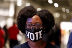 FILE - Ashley Nealy waits in line to cast her ballot during early voting for the presidential elections inside of the Atlanta Hawks' State Farm Arena in Atlanta, Georgia, October 12, 2020.