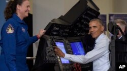 President Barack Obama sits in a flight simulator during a tour of innovation projects at the White House Frontiers Conference at University of Pittsburgh in Pittsburgh, Oct. 13, 2016, as NASA astronaut Dr. Serena Aunon-Chancellor watches.