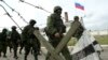 Military personnel, believed to be Russian servicemen, march outside the territory of a Ukrainian military unit in the village of Perevalnoye outside Simferopol, March 4, 2014.