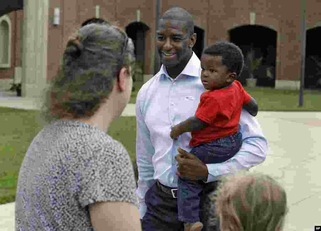 Florida Democratic gubernatorial candidate Andrew Gillum, holding his son Davis, smiles as he talks to supporters after voting, Nov. 6, 2018, in Tallahassee, Fla.