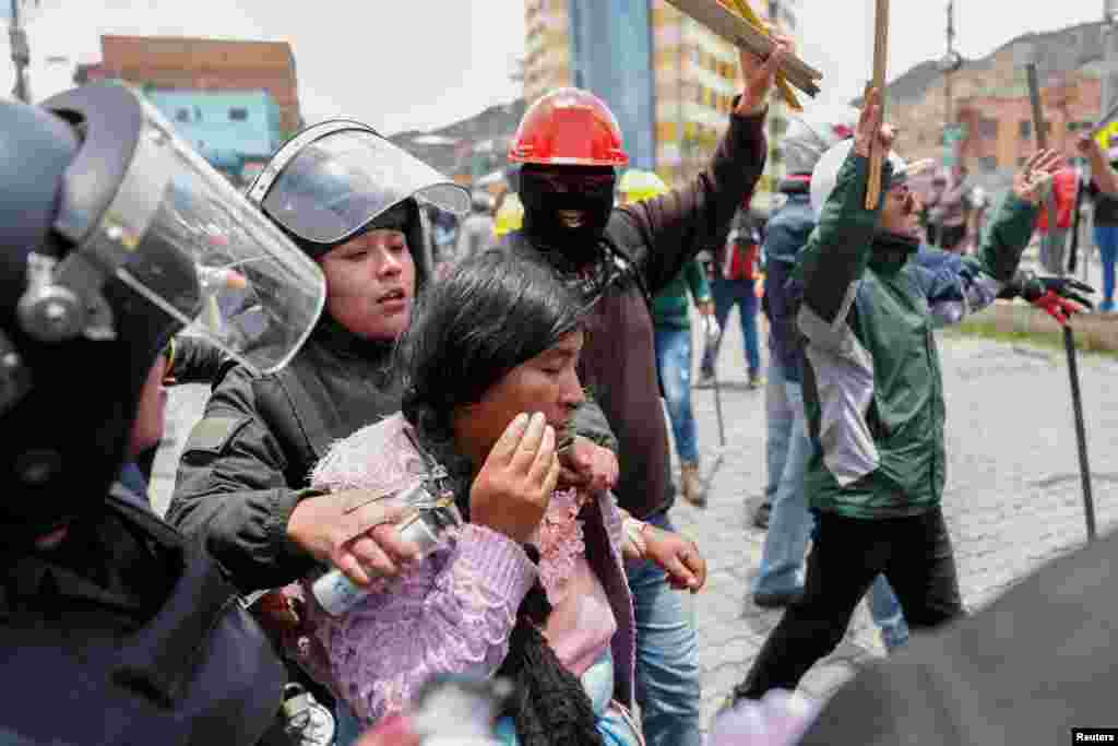 Agentes de policía detienen a un mujer que participó en las protestas que enfrentaron a seguidores y opositores de Evo Morales, que el domingo presentó su renuncia ante la presión social e internacional.