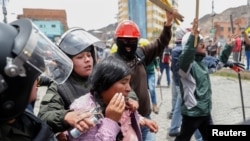 La policía detiene a una mujer durante los enfrentamientos entre seguidores y opositores del expresidente Evo Morales en La Paz, Bolivia.