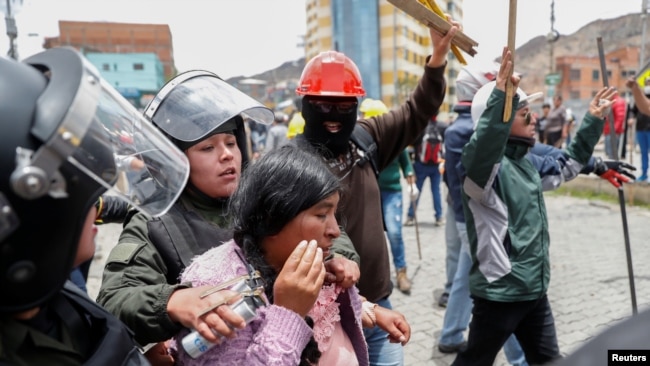 莫拉莱斯支持者和反对派支持者在玻利维亚首都拉巴斯发生冲突，其间警察拘捕一名女子。(2019年11月11日)