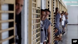 FILE - Prisoners look out from their cells at the Combinado del Este prison during a media tour in Havana, Cuba, Apr. 9, 2013.