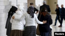 Israeli women, friends and relatives of two Jewish citizens who, according to Israel Radio, were indicted for a July 31 arson attack, walk together outside a courtroom at the District court in Lod, central Israel, Jan. 3, 2016.