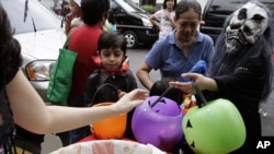 Des enfants portant des masques d'Halloween reçoivent des bonbons pendant la tradition «Trick or Treat» à Makati à Manille le 31 octobre 2008. Les parents doivent surveiller la consommation de sucre de leurs enfants selon le Dr Mary Hayes, dentiste pédiatre à Chicago. AP/Marquez
