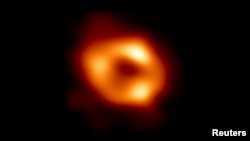 Première image de Sagittarius A*, trou noir supermassif au centre de la Voie lactée, prise par le réseau de télescopes Event Horizon (EHT). La vue capture la lumière courbée par la puissante gravité du trou noir, qui est quatre millions de fois plus massif que notre Soleil.