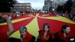 Massa pendukung pemerintah berdemonstrasi di depan gedung Parlemen di Skopje, Macedonia (18/5). (AP/Boris Grdanoski)