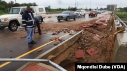 Gaborone City Council workers inspect a road damaged by the floods, in Botswana, Feb. 20, 2025.