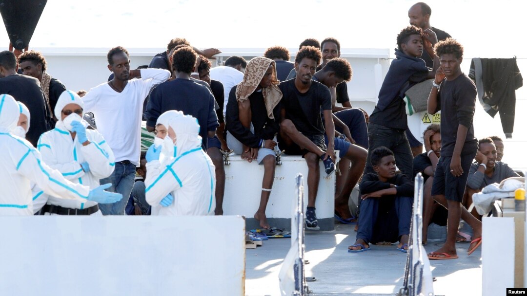 FILE - Migrants wait to disembark from the Italian coast guard vessel "Diciotti" at the port of Catania, Italy, Aug. 22, 2018.