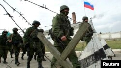 Military personnel, believed to be Russian servicemen, march outside the territory of a Ukrainian military unit in the village of Perevalnoye outside Simferopol, March 4, 2014.