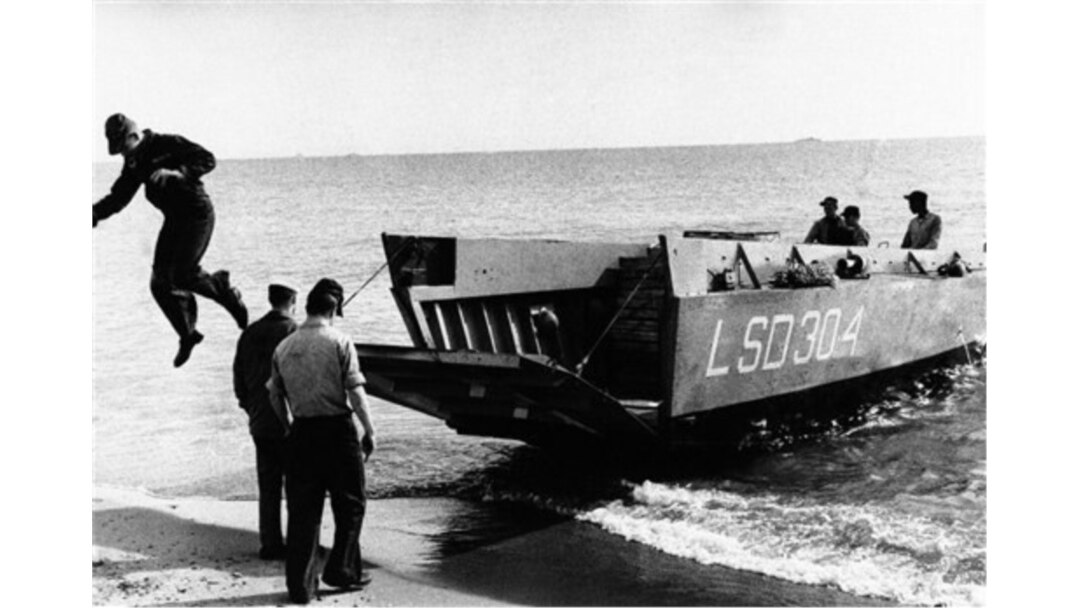 FILE - A navy man jumps from a small landing craft after searching the sea near Palomares, Spain, Feb. 9, 1966.
