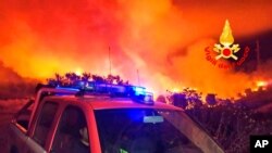 This photo released by the Italian Firefighters shows a fire near Mandas, in the south of Sardinia, Italy, in the early hours of Aug. 12, 2021.