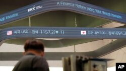 A man stands near a screen showing the foreign exchange rates at the Korea Exchange in Seoul, South Korea, Oct. 8, 2020.