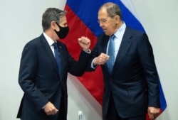 U.S. Secretary of State Antony Blinken, left, greets Russian Foreign Minister Sergey Lavrov, right, as they arrive for a meeting at the Harpa Concert Hall in Reykjavik, Iceland, May 19, 2021.