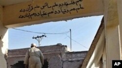 Pakistani men inspect the damage after suspected militants blew up a school building in Khyber region's Bara town, around 20 kilometers (13 miles) south of Peshawar, 21 Nov 2009