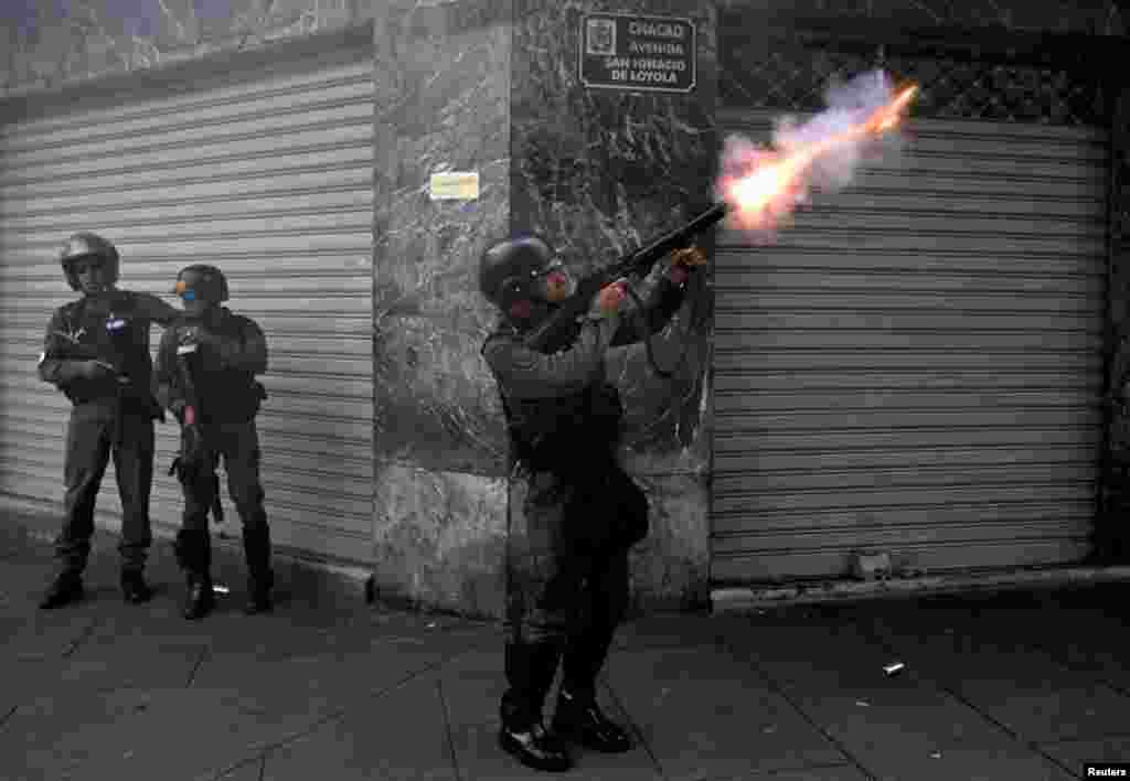 A riot police officer fires tear gas while clashing with demonstrators during a rally in Caracas, Venezuela, April 8, 2017.