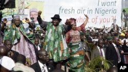 Nigeria’s President Goodluck Jonathan (C) leaves a rally with his wife Patience and Vice President Namadi Sambo (L) after declaring his bid for the 2011 presidential poll in Abuja, 18 Sep 2010