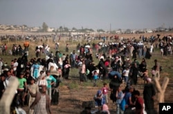 FILE - Thousands of Syrian refugees walk toward Turkey, June 14, 2015.