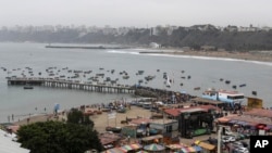 ARCHIVO - La gente se reúne en el puerto pesquero para una procesión en honor a San Pedro en el distrito de Chorrillos de Lima, Perú, el jueves 29 de junio de 2017.