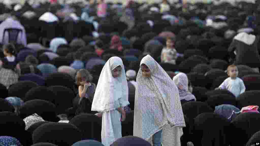 En Palestine, deux jeunes filles musulmanes en vêtements traditionnels prennent part à la prière de l'Aïd al Fitr, le 17 juillet 2015.