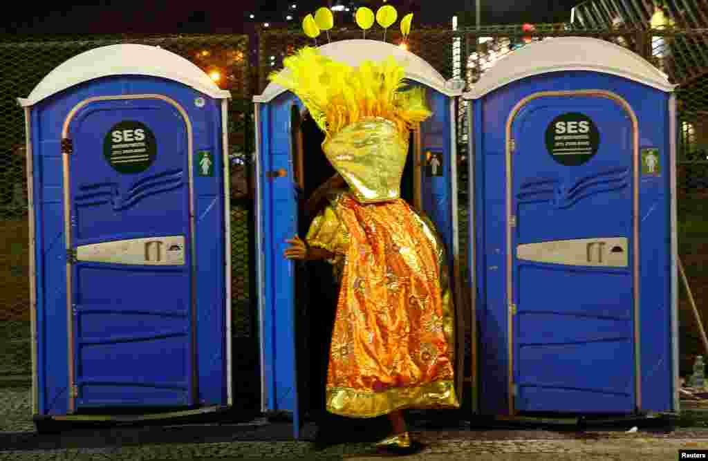 A reveler enters a chemical toilet before the first night of the Carnival parade of samba schools at the Sambadrome in Rio de Janeiro, Brazil, Feb. 26, 2017.