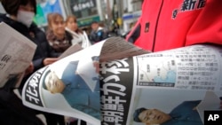 Copies of an extra edition of a Japanese newspaper reporting North Korea's nuclear test are handed out to passers-by in Tokyo Feb. 12, 2013.