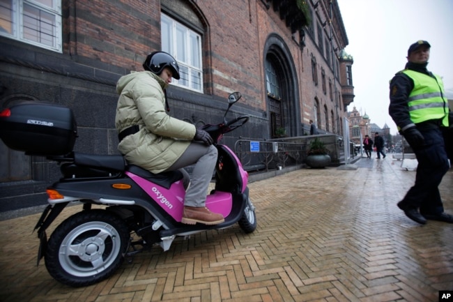 FILE - A Danish policeman walks away as a an electric scooter is seen in front of the Town Hall in the center of Copenhagen Dec. 15, 2009. (AP Photo/Peter Dejong)