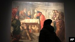 A visitor looks at Tintoretto's "Presentation of Jesus in the Temple" at the Ducal Palace in Venice, Dec. 3, 2018. After the show closes in January, it moves to the National Gallery of Art in Washington in the first Tintoretto retrospective outside Europe.